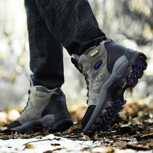 Person wearing gray hiking boots with blue soles on a forest path