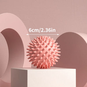 Pink textured massage balll with measurement text on a pink background