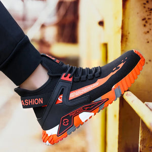 Black and orange safety work boots with 'FASHION' text on a blurred background