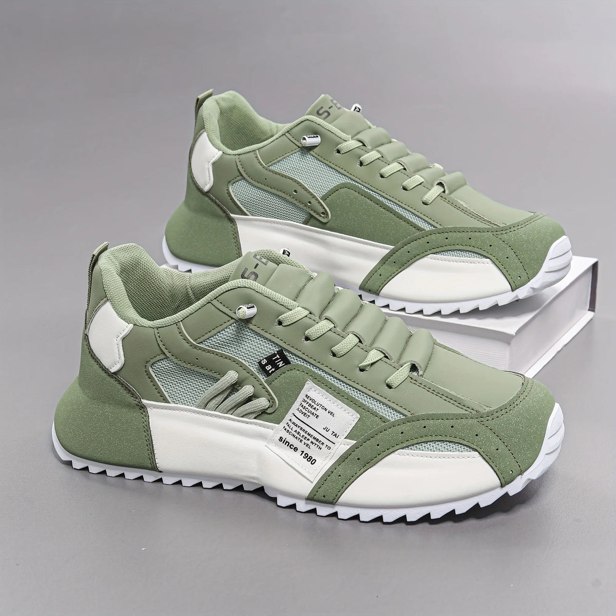 Green and white sneakers on a gray background