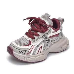 White and burgundy children's sneaker on a white background