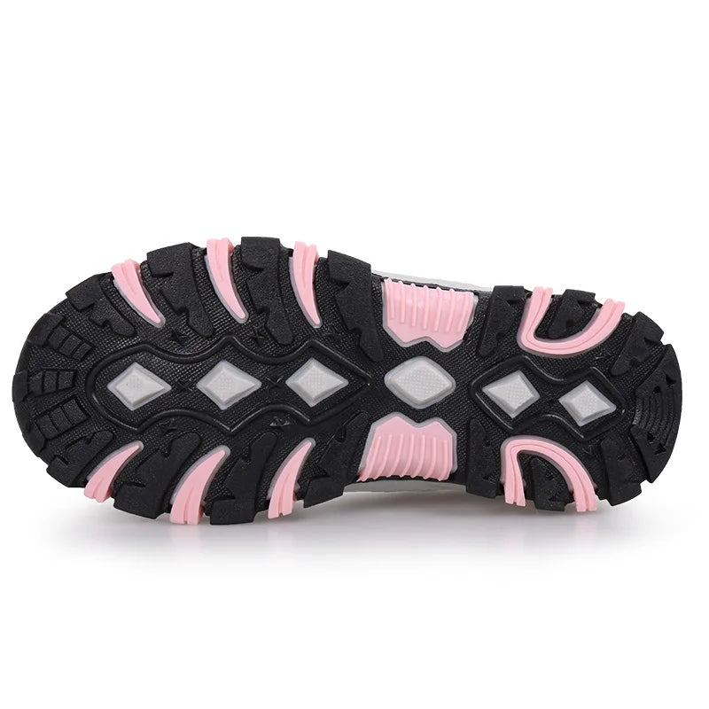 A close-up of a shoe's outsole showing a black tread pattern with pink accents and translucent gray diamond-shaped grooves, set against a plain white background.