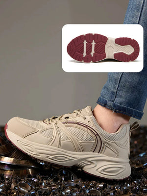 A beige athletic sneaker with dark red sole details, shown worn on a person's foot with blue jeans visible. An inset at the top shows the outsole design in detail against a gray background.