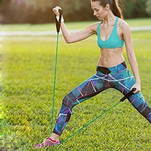 Woman exercising outdoors using resistance bands on a grassy area