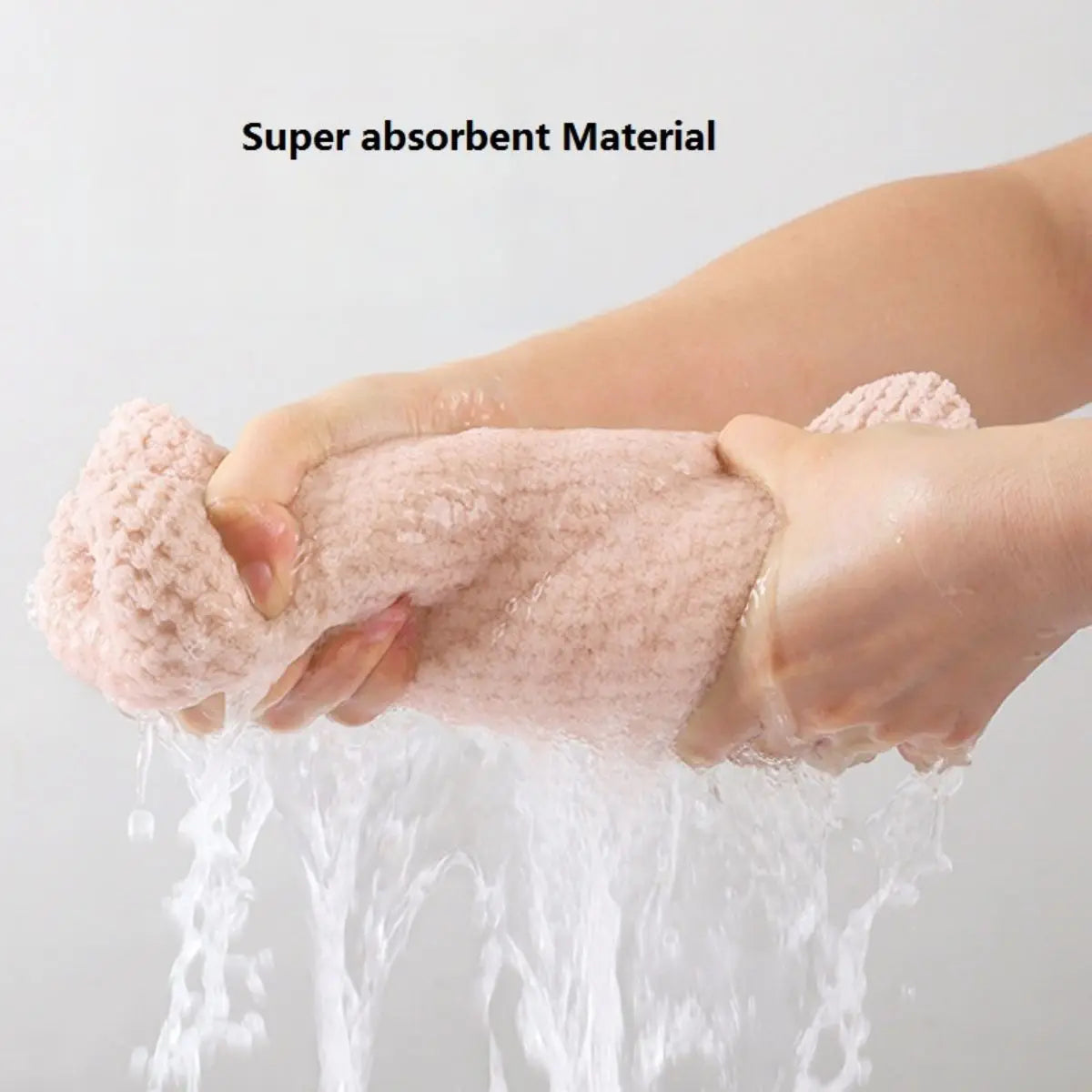 Person holding a super absorbent hair towel wrap with water dripping from it on a plain background