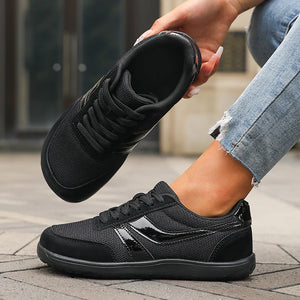Person wearing black athletic shoes on a pavement background