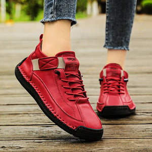 Red Slip-On Shoes with black soles on a wooden floor