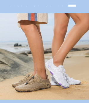 Two pairs of shoes on a beach with a clear sky.