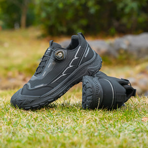Black hiking shoes on grass with a blurred natural background