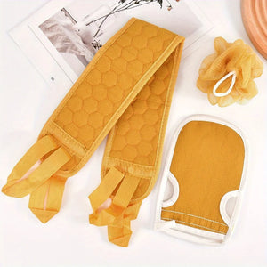 Yellow oven mitts and scrubber on a white surface with a magazine and decorative items.