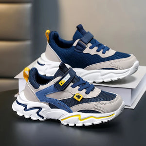 Children's blue and gray sneakers with white soles on a dark surface.