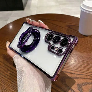 Person holding a Clear Samsung Galaxy case with electroplated frame and magnetic ring stand with a purple case on a wooden table