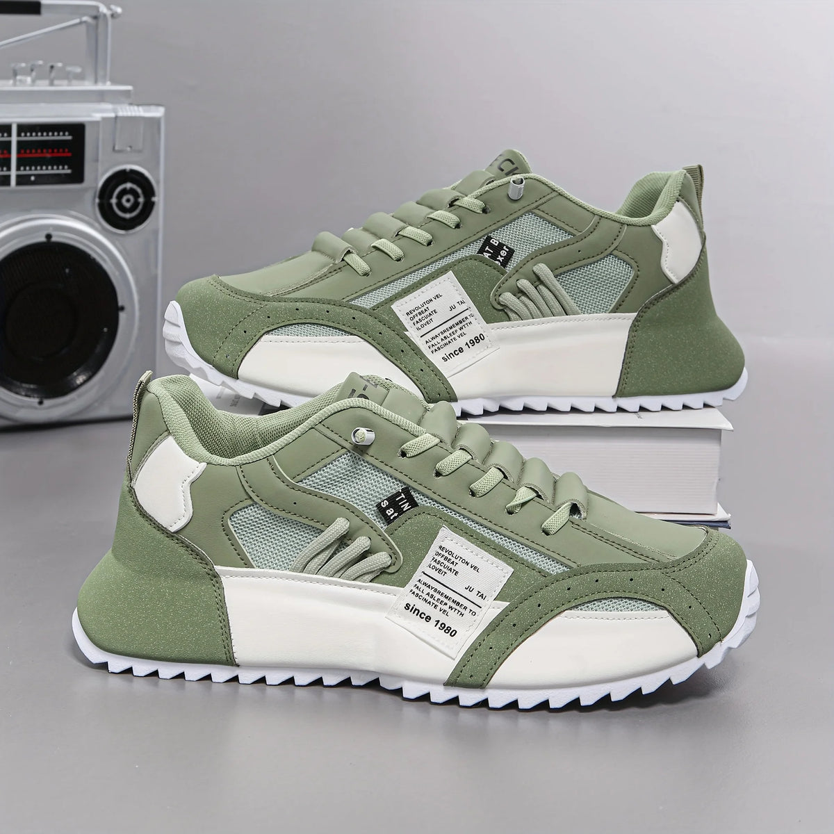 Green and white sneakers on a gray background with a vintage radio in the background.