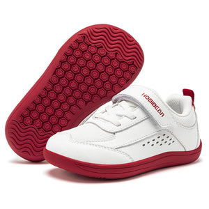 White and red baby sneakers shown on a clean white background, with one shoe standing upright to display the sole tread and the other lying flat to show the side profile.