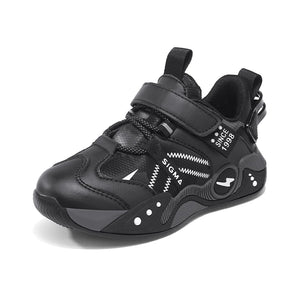 A black low-top athletic sneaker with hook-and-loop strap closures, a pull tab, and white graphic details, shown on a plain white background.