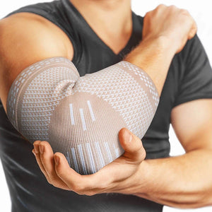 Person wearing a gray elbow support on a white background