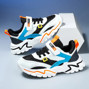 Pair of children's sneakers with black, white, blue, and orange design on a gray background