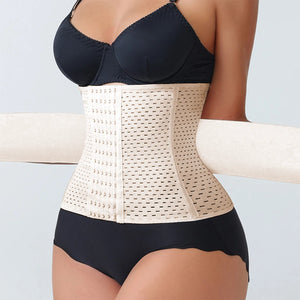 Person wearing a beige waist trainer with a black bra and underwear set on a light gray background