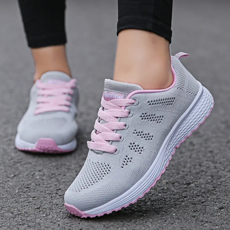 Gray and pink running shoes on a pavement background
