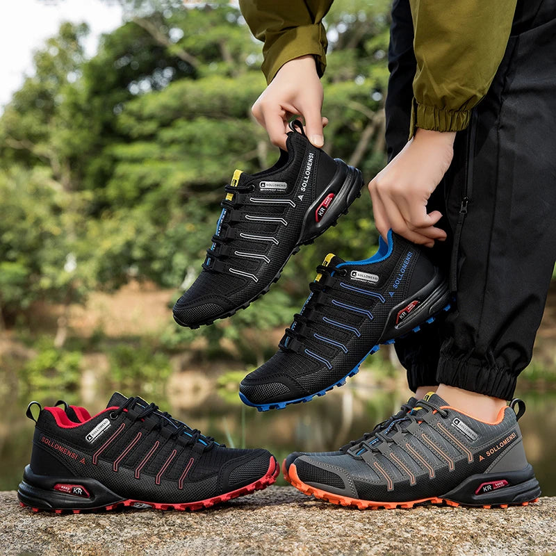 Person holding black and gray hiking shoes with a natural background