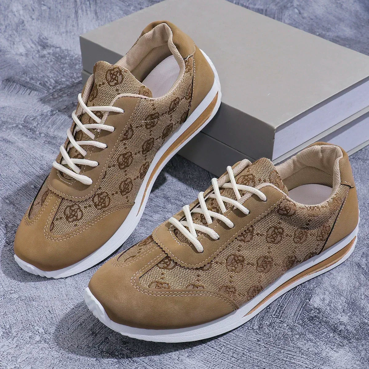 Pair of brown patterned sneakers with white laces on a textured surface.