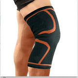 Black knee brace with orange accents on a person's knee, labeled 'Orange'.