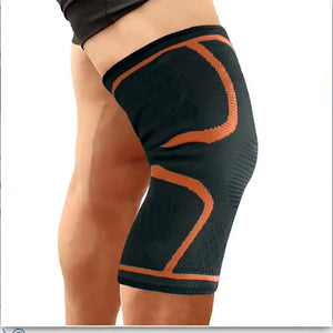 Black knee brace with orange accents on a person's knee, labeled 'Orange'.