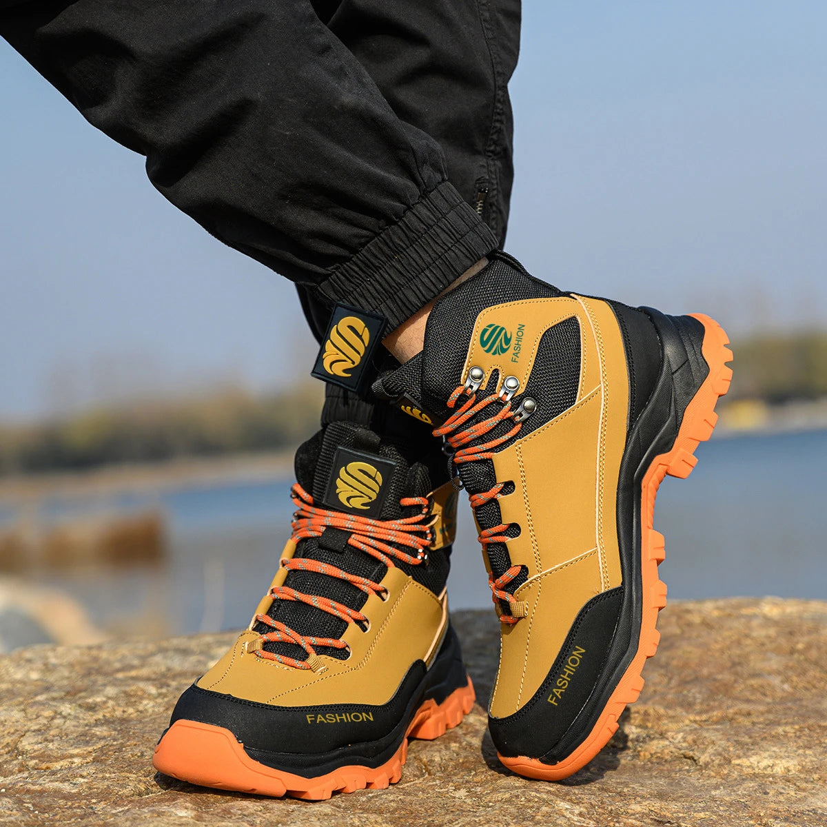 Close-up of safety boots with orange accents on a blurred natural background