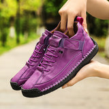 Purple sneakers held by a person with a blurred green background