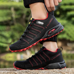 Black and red athletic shoes with visible brand logo on a blurred natural background