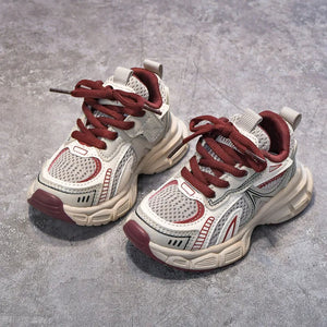 Pair of white and red sneakers on a gray concrete surface