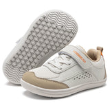 A pair of children's athletic sneakers in off-white and beige, with one shoe showing the textured sole and the other showing the side profile with a hook-and-loop strap.
