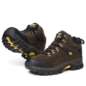 Pair of brown hiking boots with black soles and yellow accents on a white background