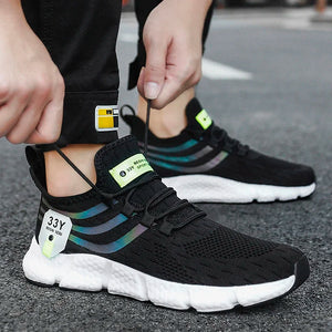 Person wearing black athletic shoes with white soles on a street.