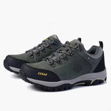 A pair of outdoor hiking shoes in gray and black with yellow accents, shown on a white background.
