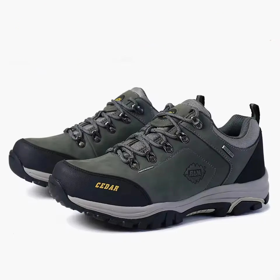 A pair of outdoor hiking shoes in gray and black with yellow accents, shown on a white background.