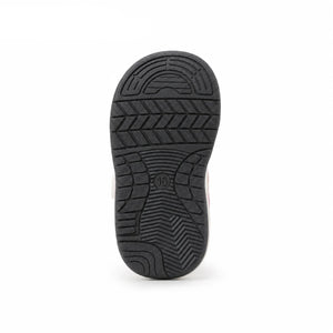 A close-up view of the black treaded sole of a shoe, shown against a white background in blue at the top left.