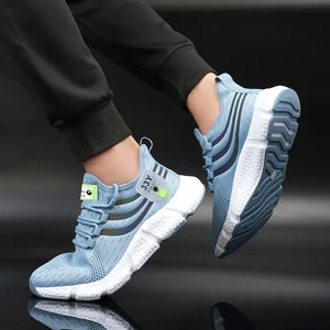 Blue running shoes with white soles worn by a person on a black background