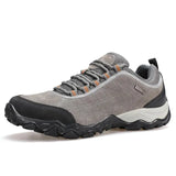 Gray hiking shoe with black sole on a white background