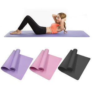 Woman exercising on a purple yoga mat with three rolled-up mats in different colors below.