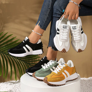 Four pairs of sneakers in black, white, green, and brown on a white platform with a blurred background.