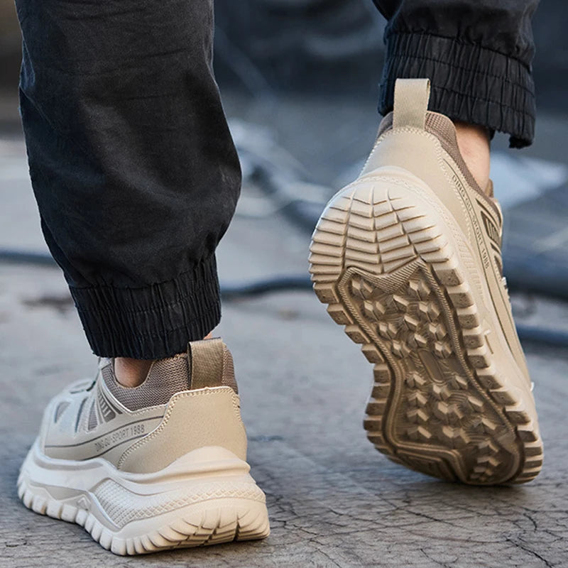 Beige safety work shoe sneakers with white soles worn by a person on a concrete surface