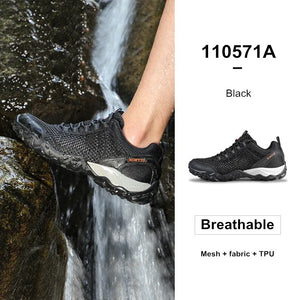 Black hiking shoe with mesh, fabric, and TPU components worn by a person near a waterfall.