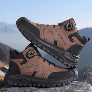 A pair of Loekan hiking boots in brown and black, displayed on a rocky surface with a blurred mountain background.