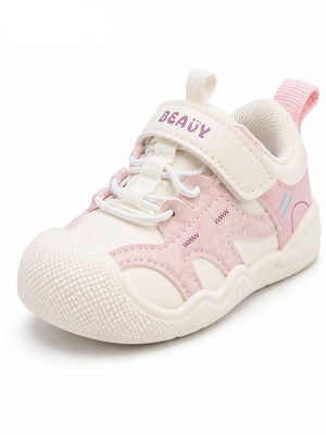A children's pink and off-white running shoe, featuring a hook-and-loop strap closure, white laces, and a textured rubber sole, shown on a white background.