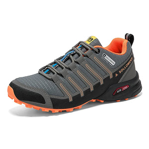 Gray and orange hiking shoe with brand logo on a white background