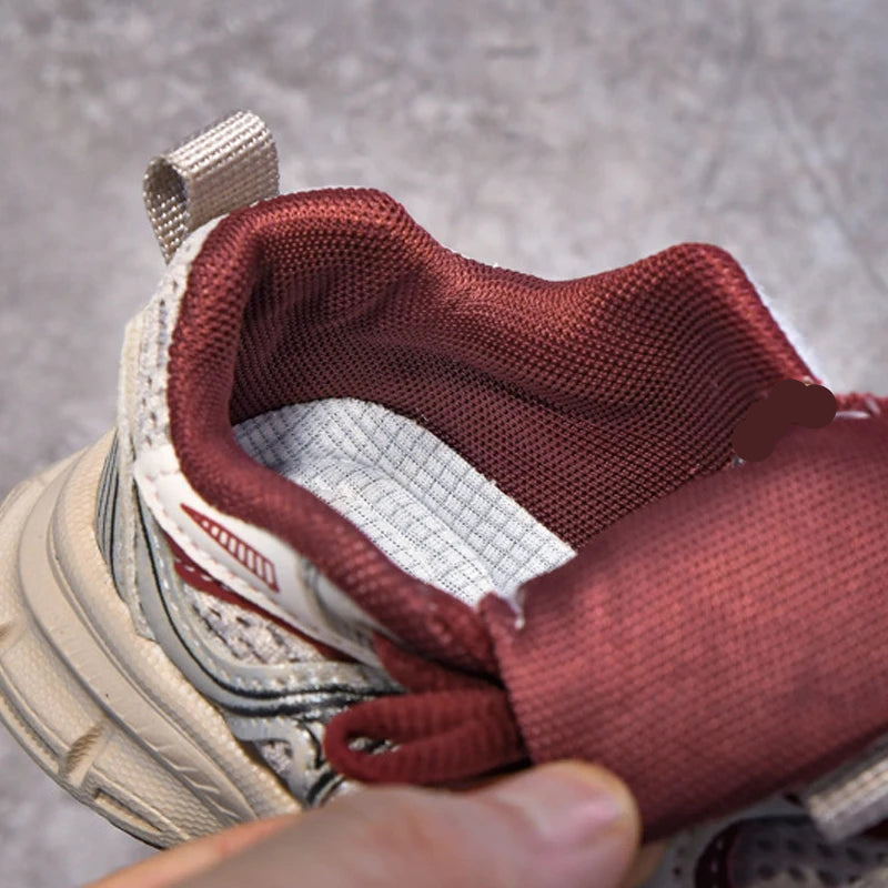 Close-up of a shoe with red lining and a person's hand adjusting it.