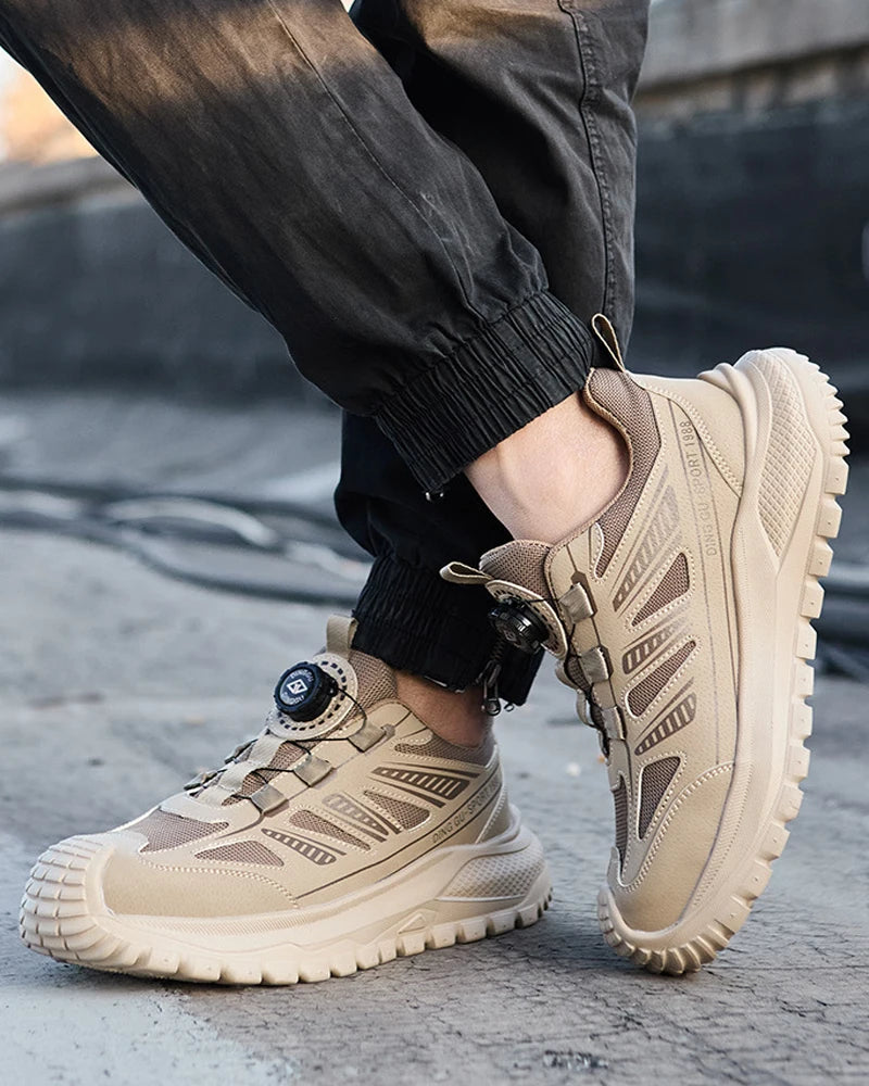 Beige tactical safety work shoes worn by a person on a concrete surface