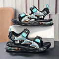 Black and turquoise sandals with air cushion sole on a gray surface.
