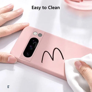 Pink phone case with a hand cleaning it using a white cloth on a light background.